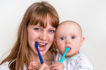 child and mother brushing teeth