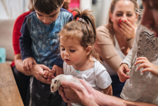 A group of children holding a rodent